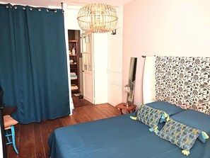 Ein Schlafzimmer mit Bett, Stuhl, Schrank und Spiegel.
