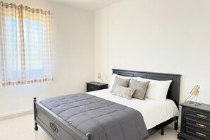 Una camera da letto con un letto, comodini e una lampada.