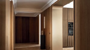 Ein Korridor mit Holzwänden und einem Küchenbereich mit Schränken.