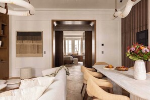 A modern interior with a dining area, a sofa, a table with a vase, and a corridor leading to another room. - Luxury A/C Apt - 10p/4bdr - Arc de Triomphe (Paris)