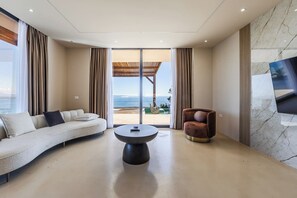 A modern living room with a sofa, armchair, and a round coffee table.