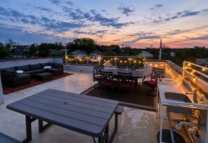 A rooftop patio with outdoor seating, a dining area, and string lights. - Skyline Views | Rooftop Deck | Minutes to Downtown (San Antonio)