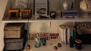 A bookshelf with books, decorative items, and a framed quote. - BB Suite Florence – Elegance, Comfort, Hospitality. (Firenze)