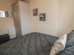 A bedroom with a bed, a wardrobe, a radiator, and two framed pictures on the wall. - Memory Maker (Bridlington)