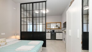 A bedroom with a bed, a bedside table, and a window with a view. - MGH- AMAI Small Holiday Cottage (Manerba del Garda)