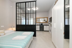 A bedroom with a bed, a bedside table, and a window with a view. - MGH- AMAI Small Holiday Cottage (Manerba del Garda)