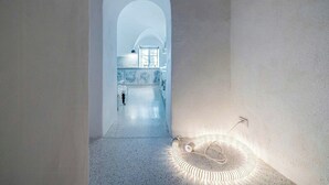 Un pasillo con un arco alto que conduce a una zona de cocina.