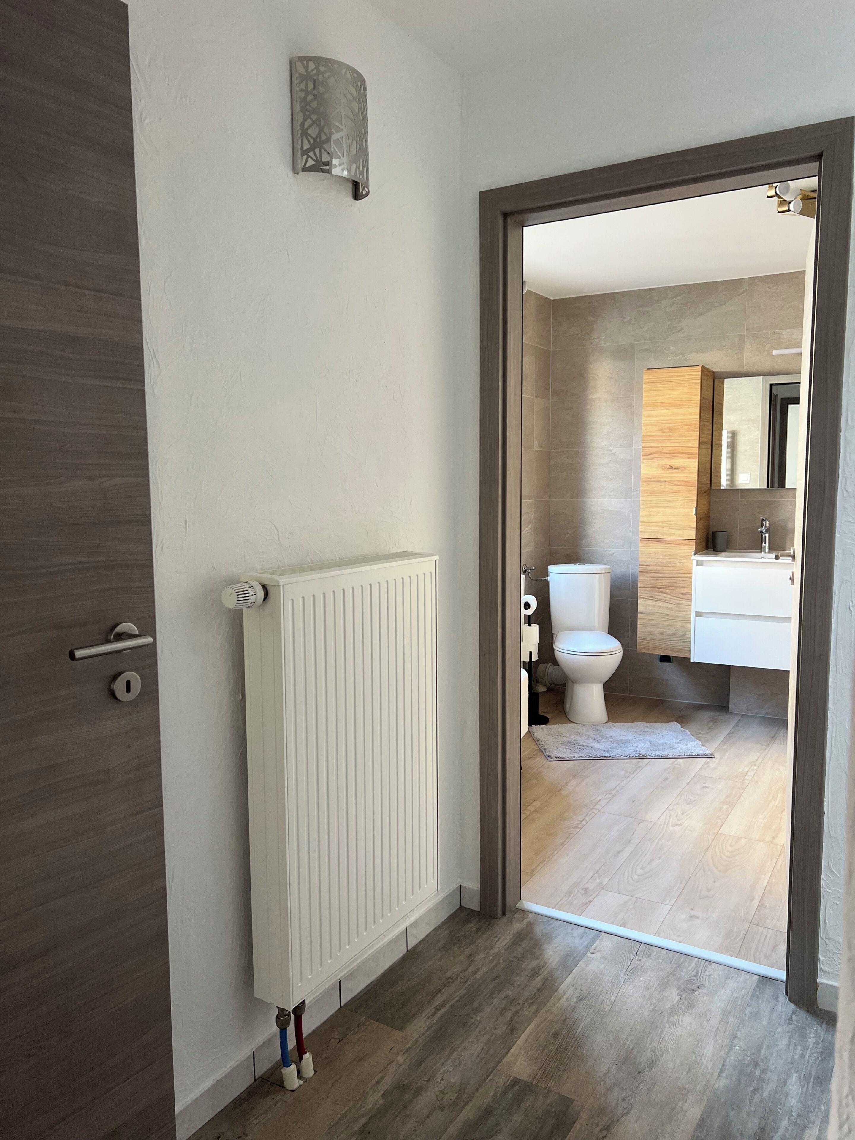 Une salle de bain moderne équipée de toilettes, d’un lavabo et d’un miroir.