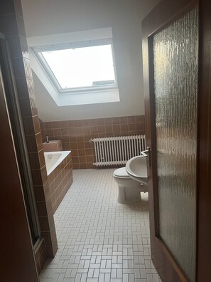 Et badeværelse med skydelugt, en radiator, et toilet og en vask.