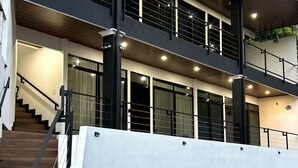A modern building with a staircase, multiple balconies, and a covered outdoor area. - Duke's Place (Quepos)