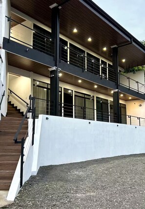 A modern building with a staircase, multiple balconies, and a covered outdoor area. - Duke's Place (Quepos)