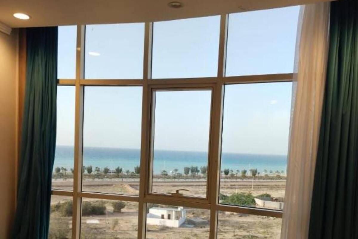 Un dormitorio con un ventanal grande, una cama y vistas a un paisaje.