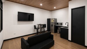 Une petite cuisine moderne équipée d’un réfrigérateur, d’un four à micro-ondes et d’un évier.
