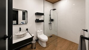 Une salle de bain moderne avec un lavabo en marbre, des toilettes, un espace douche et un miroir.