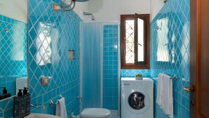 A bathroom with a sink, toilet, bidet, and washing machine. - Casa del Leccio F4 by Wonderful Italy (San Teodoro)