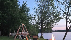 A lakeside setting with a swing set, a fire pit, and a view of the water. - River & Nature - Nook Richelieu (Henryville)