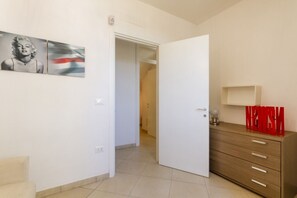 Ein Zimmer mit einer weißen Tür, einem Holzkapfen und einem Wandbild in einem Rahmen.