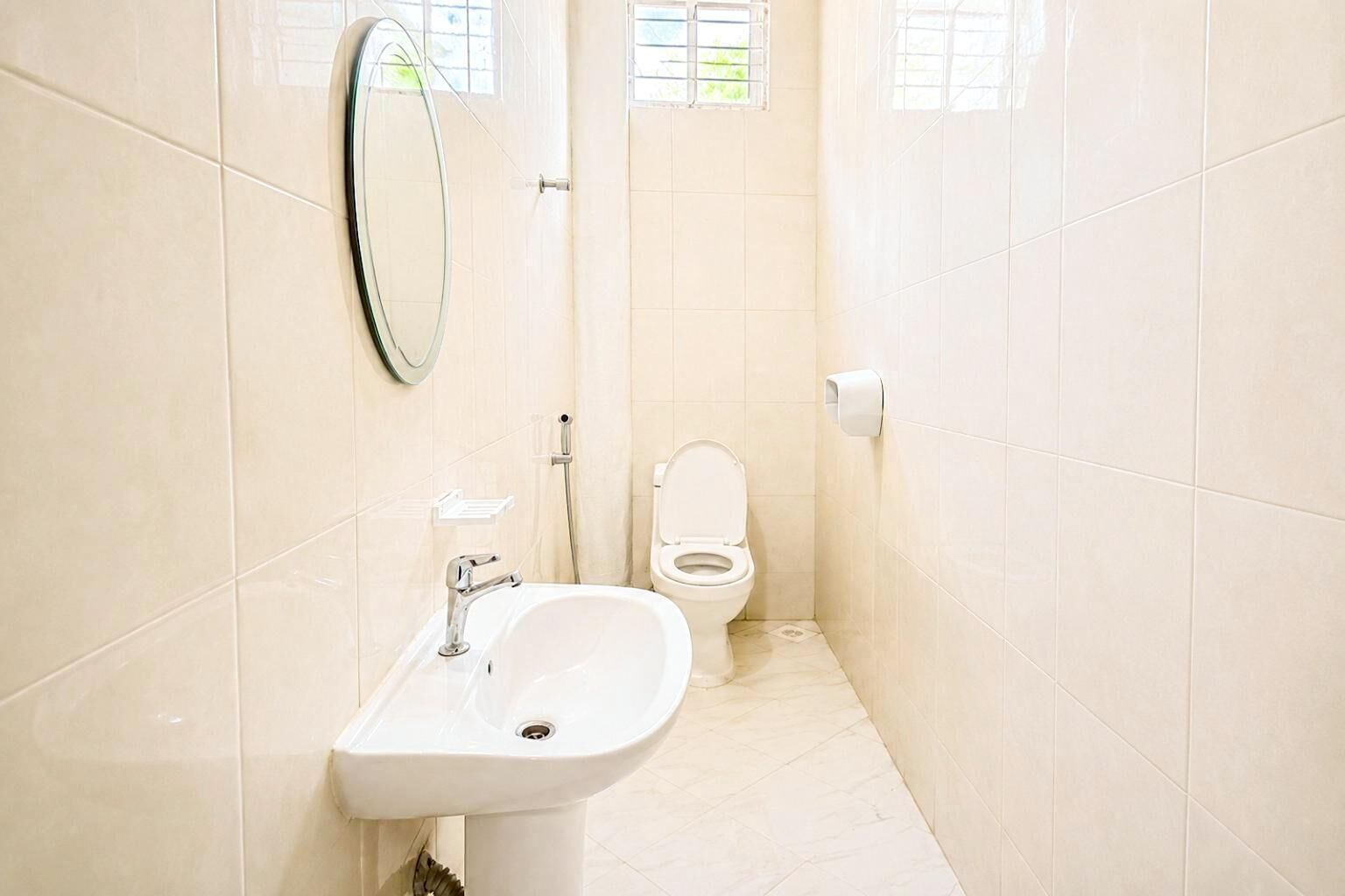 Une salle de bain avec un lavabo, des toilettes et un miroir au mur.