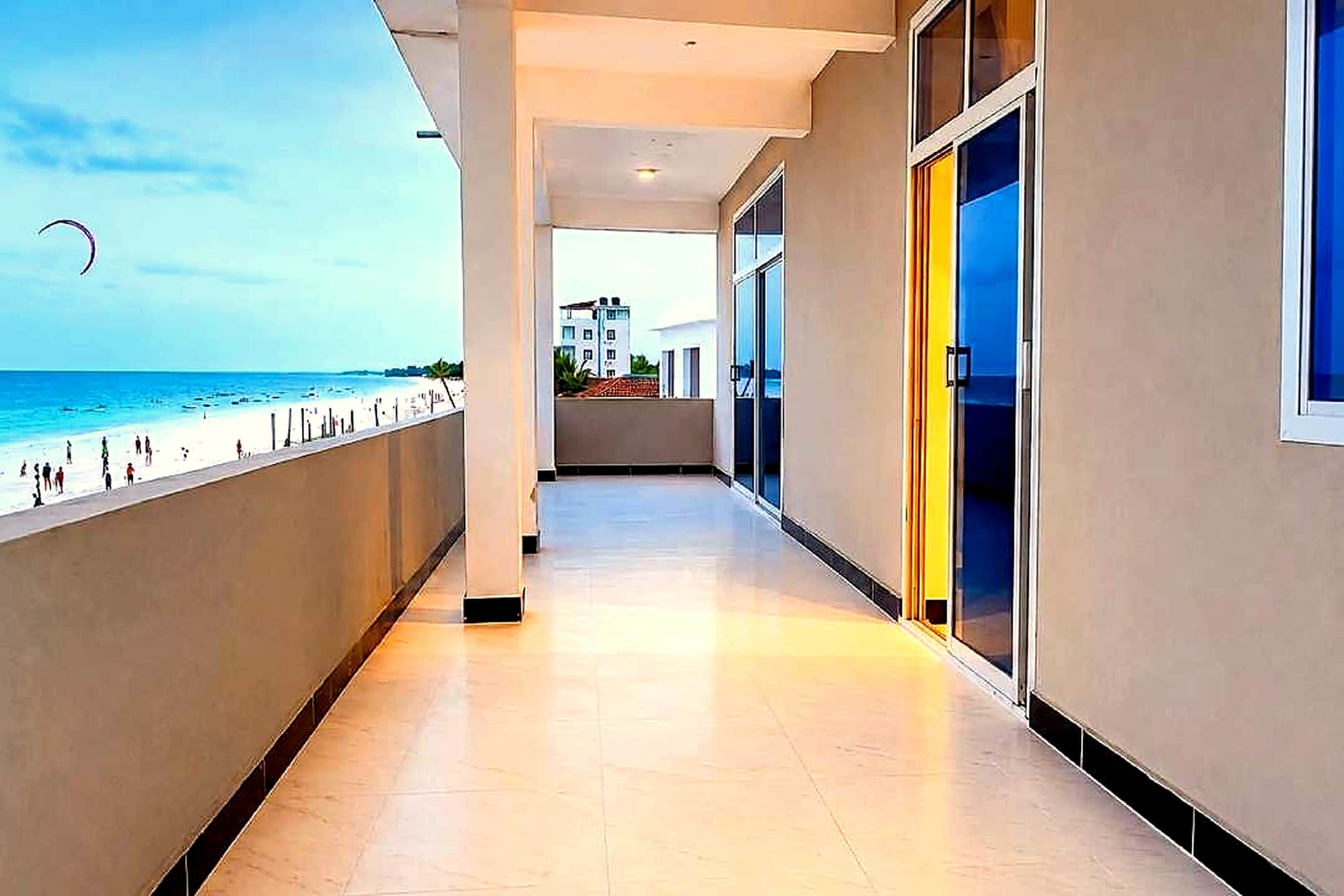 Oceanfront balcony with direct beach views - watch kite surfers over Uroa's turquoise bay