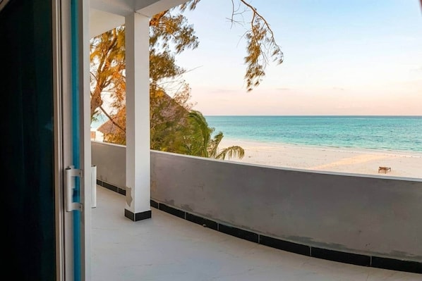 Un balcon avec vue sur une plage et l’océan.