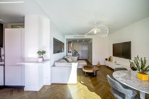 A modern living space with a sofa, dining table, and kitchen area. - Perfect 2-Bedroom Apartment with AC, Sea View & Terrace in Charming Nice, Garage (Nice)