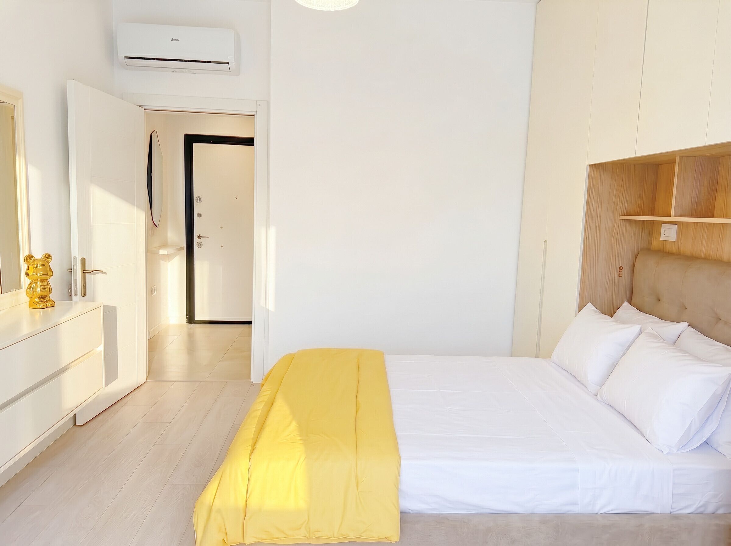 Une chambre à coucher avec un lit, une table de chevet, un miroir et une armoire.