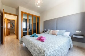 Ein Schlafzimmer mit einem großen Bett, einem Kleiderschrank und einem Nachttisch.