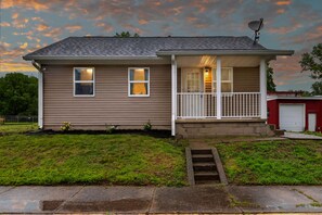 A single-story house with a front porch, a satellite dish, and a garage. - Cozy Crane Cottage, WestGate~3 Bedroom 2 Bathroom~ (Crane)