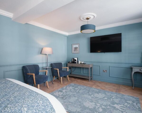 A room with a bed, two chairs, a desk, a television, and a lamp. - Lowcross House (Whitchurch)