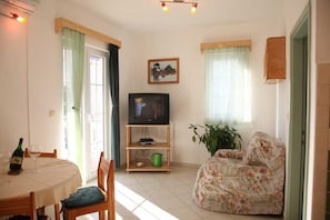 A living room with a television, a sofa, a dining table with chairs, and a potted plant. - Srima Villa Steps From Sandy Beach (Vodice)