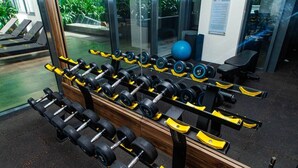 A gym with multiple rows of dumbbells, exercise balls, and benches. - Solaris Premier 1BR | Osu • Pool • Gym (Accra)