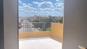 A view from a balcony with a clear sky and clouds, a tiled floor, and a metal railing. - Vista Central Park Caucel3 Habitaciones (Caucel)
