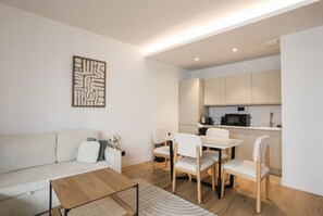 Una sala de estar moderna con un sofá, una mesa de centro y un comedor con sillas y una mesa.