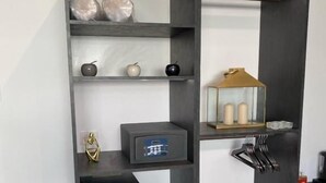 Une chambre moderne aux couleurs noir et blanc, comprenant un bureau avec un ordinateur, une chaise et un petit coin salon.