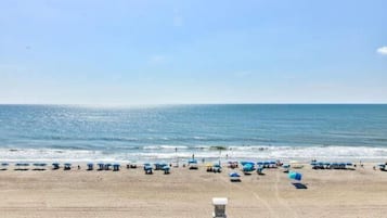 Een strand met parasols en een redershut.
