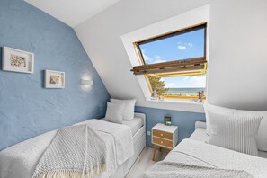 A bedroom with a skylight, a bed, a bedside table, and a view of the outdoors. - Kronsgaard Beach Loft - Ocean View, Activity Room, Playground, Balcony (Kronsgaard)