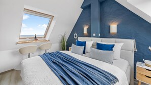 Makuuhuone, jossa on sänky, ikkuna, työpöytä ja tuoli.