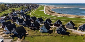 Ein Küstenwohngebiet mit Häusern, die in Reih und Glied an einer gewundenen Straße entlang zum Strand führen.