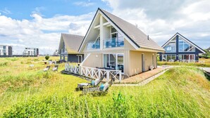 Ein modernes Strandhaus mit Balkon, Terrasse und Meerblick.