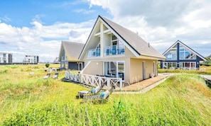 Ein modernes Strandhaus mit Balkon, Terrasse und Meerblick.