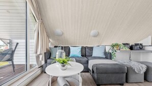 Ein modernes Wohnzimmer mit einer Couch, einem runden Tisch und einer Topfpflanze.