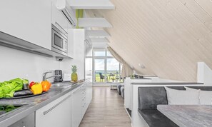 Eine moderne Küche mit Essbereich, Blick ins Freie und einer eingebauten Bank.