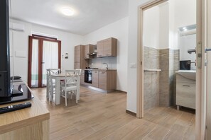 A modern kitchen with wooden cabinets, a dining table with chairs, and a built-in oven.
