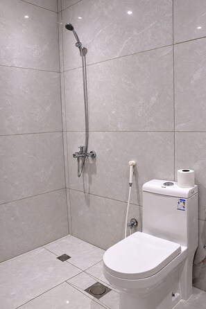 Un baño moderno con inodoro, ducha y bidé.