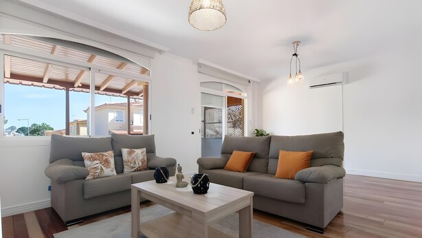 Een moderne woonkamer met twee banken, een salontafel en een plafondlamp.