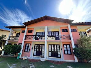 A multi-story building with balconies, a tiled roof, and a well-maintained lawn. - Dwelling place of Israel, Revelation 30 (Porto Seguro)