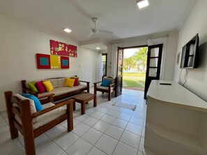 A living room with a sofa, chairs, a coffee table, a TV, and a ceiling fan. - Dwelling place of Israel, Revelation 30 (Porto Seguro)