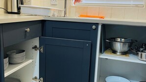 A kitchen with a built-in oven, a sink, and a window with blinds.