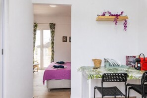Une chambre à coucher comprenant un lit, une chaise, une table et une étagère avec divers objets.