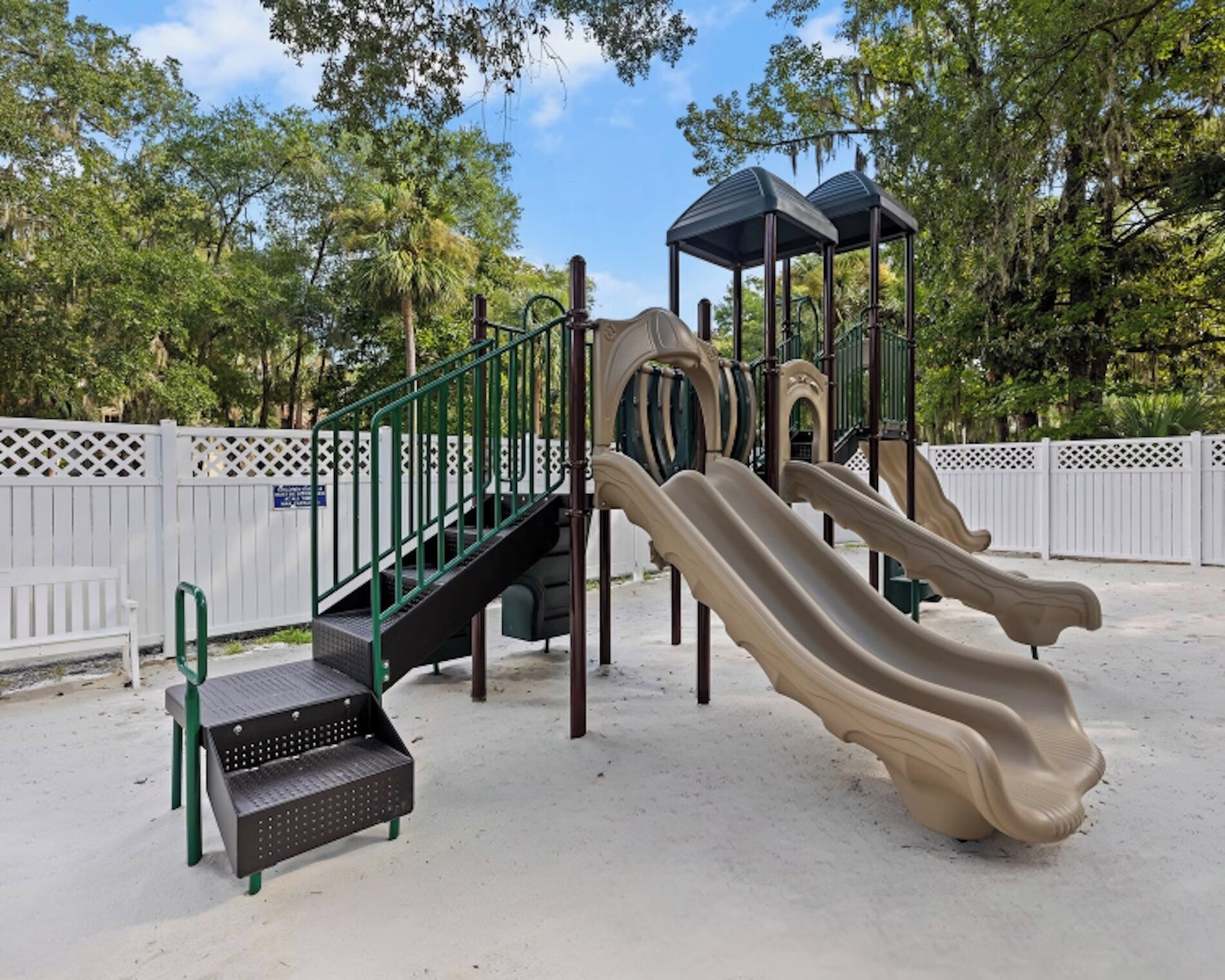 Ein Spielplatz mit Rutsche, Klettergerüst und einer Bank.
